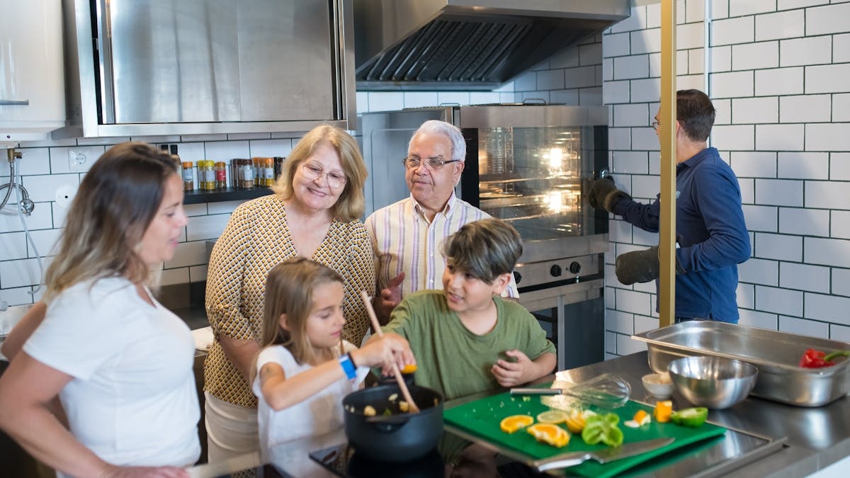 Multi-generational family preparing a meal together in a contemporary kitchen setting.